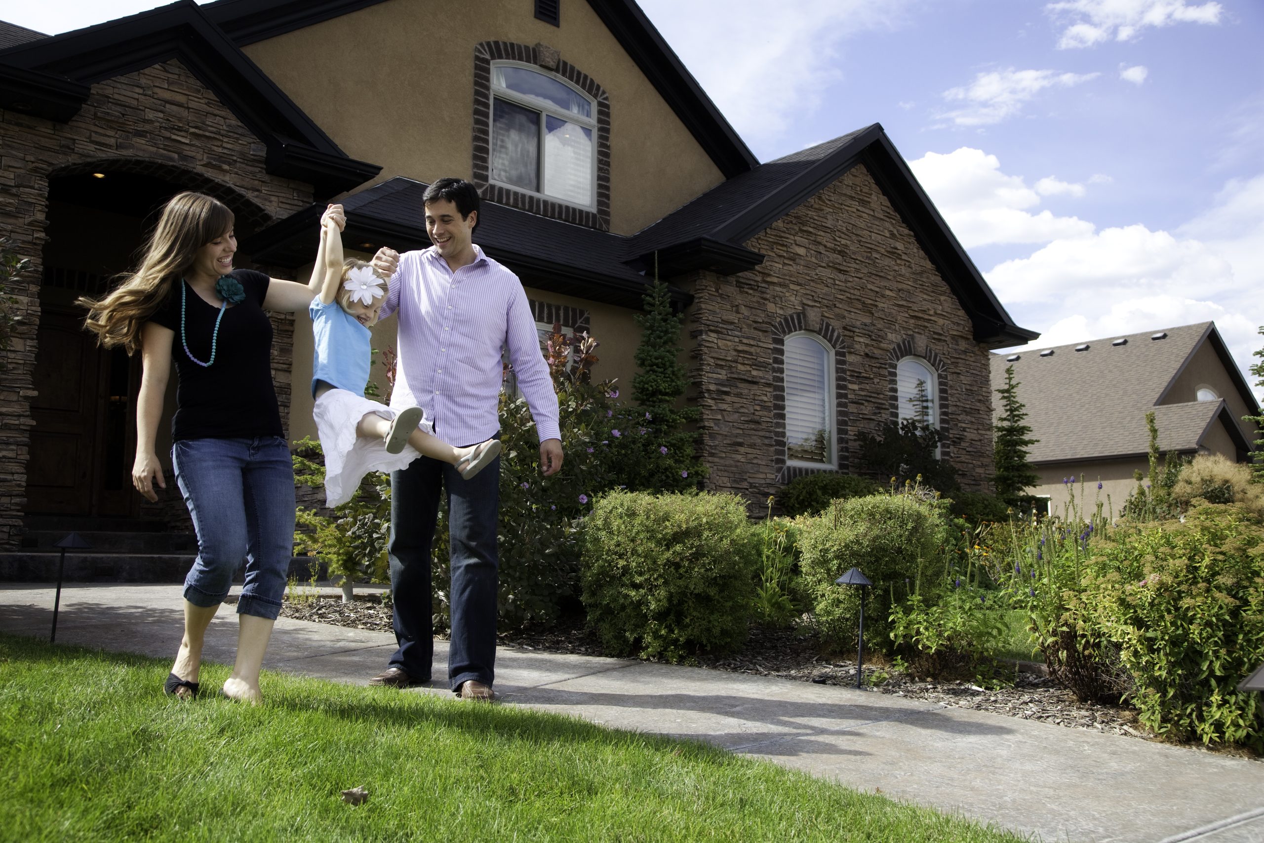 Cute Young Couple and Child with Beautiful Home